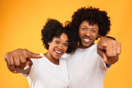 Photo for We choose you. Cool african american friends stylish millennial attractive man and woman with curly hair pointing and smiling at camera, hugging, posing on colorful studio background - Royalty Free Image