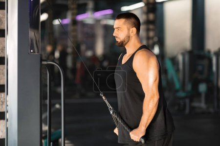 Photo for Athletic Young Man Training Muscles With Cable Machine At Gym, Motivated Male Athlete Using Modern Sport Equipment While Exercising, Doing Intense Workout, Enjoying Active Lifestyle, Copy Space - Royalty Free Image