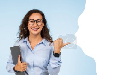 Photo for Cheerful caucasian young businesswoman with computer points thumb finger at copy space bubble for text, on blue studio background. Work offer, business recommendation. Panorama, collage - Royalty Free Image