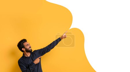 Photo for Excited middle eastern guy points excitedly at ad banner with empty speech bubble, promoting discount offer, against yellow studio background, collage, panorama. Look at this deal concept - Royalty Free Image