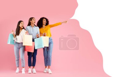Photo for Three excited diverse ladies with colorful shopping bags pointing at empty text bubble, recommending nice offer or black friday sale advertisement, standing over pink background, panorama, collage - Royalty Free Image