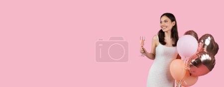 Téléchargez les photos : Femme souriante en robe blanche toastant avec une coupe de champagne, tenant des ballons festifs en cuivre et rose sur fond rose doux, incarnant la célébration, panorama, espace libre - en image libre de droit