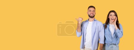 Photo for Excited man showing free space pointing aside, woman holding hand on cheek, both sharing cheerful moment and presenting advertisement, on yellow background, banner - Royalty Free Image