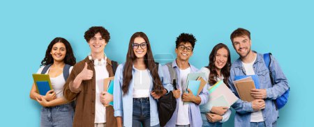 Photo for Enthusiastic group of five young students with backpacks and books giving a thumbs-up, standing confidently against a turquoise blue background, panorama, studio. Study, education - Royalty Free Image