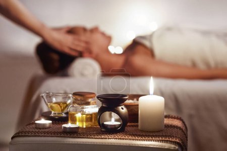 Téléchargez les photos : Aroma Spa. Fille bénéficiant d'un massage dans un spa de luxe avec des bougies au premier plan - en image libre de droit