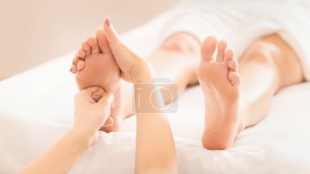 Téléchargez les photos : Massage des pieds. Femme relaxante au salon de spa, traitement de réflexologie - en image libre de droit