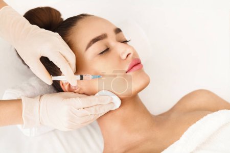 Téléchargez les photos : Chirurgie plastique. Jeune femme recevant l'injection de Botox dans la clinique de beauté - en image libre de droit
