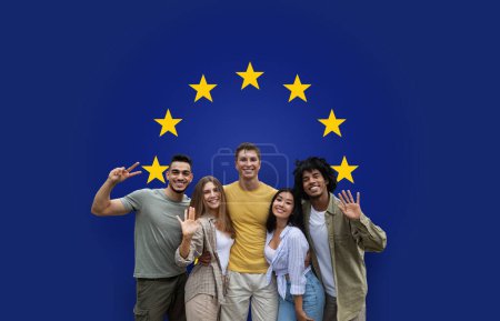 Photo for Five cheerful millennial friends showing peace signs and waving, standing together with genuine smiles under the symbolic stars of the European Union flag, radiating friendship - Royalty Free Image