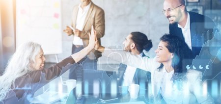 Photo for Energetic business team celebrating a success with a high-five in a collaborative office setting, with stock market growth charts symbolizing achievement and progress, panorama - Royalty Free Image