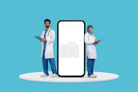 Male and female doctors, with clipboard in hand, standing next to massive vertical smartphone screen, perfect for health app adverts, blue background, mockup