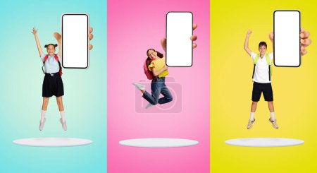 Téléchargez les photos : Trois écoliers en uniforme sautant joyeusement avec smartphone vierge à la main sur fond pastel lumineux, enfants heureux démontrant une nouvelle application mobile, offre de publicité en ligne, collage, maquette - en image libre de droit