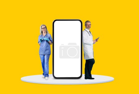 Photo for Female and male doctors next to an oversized smartphone screen, suggesting telemedicine advancements, yellow background, mockup - Royalty Free Image