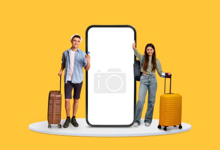 Smiling young male and female travelers holding suitcases, standing beside a giant smartphone mockup on a vibrant yellow background, perfect for travel apps