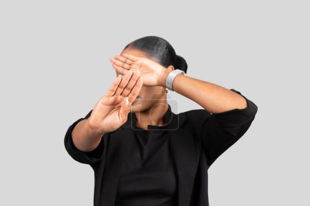Téléchargez les photos : Femme afro-américaine professionnelle du millénaire en costume d'affaires faisant un geste de timeout avec ses mains, indiquant une pause ou un besoin d'une pause, sur un fond clair - en image libre de droit