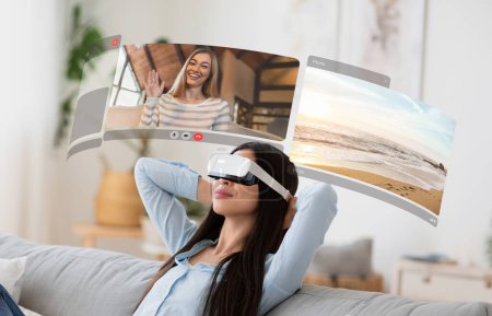 Foto de Mejorar las conexiones: mujer asiática joven se sumerge en la realidad virtual para los chats de vídeo realistas de su casa, relajarse en el sofá con pantallas digitales - Imagen libre de derechos