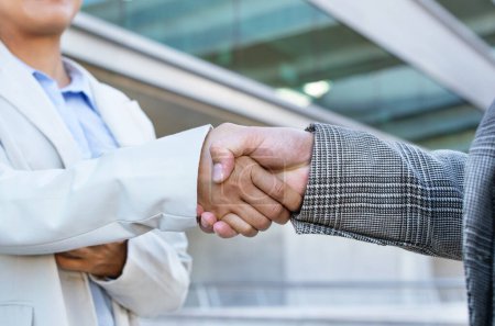 Photo for Employment Deal. Closeup Of Two Unrecognizable Business People Handshaking Outdoor Office Building. Cropped Shot Of Businesswoman And Businessman Shaking Hands in Agreement. Partnership - Royalty Free Image
