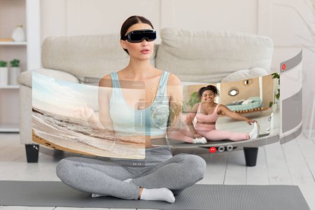 VR fitness at home. Athletic sporty young woman in sportswear sitting on yoga mat in living room, using VR glasses and exercising, communicating with her coach