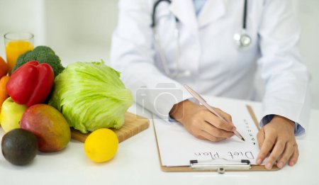 Photo for Nutritionist desk with healthy fruit, juice and measuring tape. Cropped of woman dietitian working on diet plan. Weight loss and right nutrition concept, panorama - Royalty Free Image