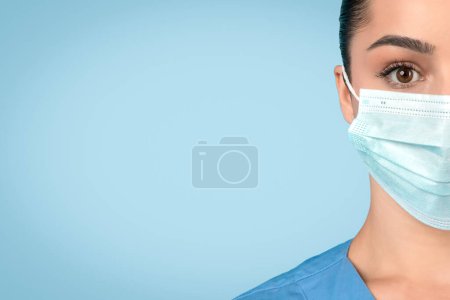 Téléchargez les photos : Gros plan sur le visage des infirmières portant un masque chirurgical, soulignant l'importance des mesures de protection dans les soins de santé, les yeux focalisés, fond bleu, espace libre - en image libre de droit