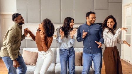 Photo for Multiracial group of friends dancing enjoying students party on weekend, making funny moves at modern apartment interior, having fun together during social event gathering. Panorama - Royalty Free Image