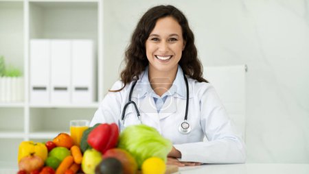 Photo for Nutritionist desk with healthy fruit, juice and measuring tape. Cheerful european young woman dietitian working on diet plan at clinic. Weight loss and right nutrition concept, panorama - Royalty Free Image