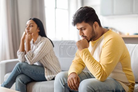 Photo for Upset Indian Man And Woman Offended To Each Other After Argue At Home, Pensive Eastern Spouses Sitting On Couch With Pensive Face Expression, Suffering Relationship Crisis After Domestic Quarrel - Royalty Free Image