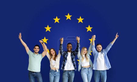 Foto de Cinco jubilosos amigos milenarios levantan sus brazos en un gesto de celebración, transmitiendo emoción y éxito en el contexto de la bandera de la Unión Europea, estudio, panorama - Imagen libre de derechos
