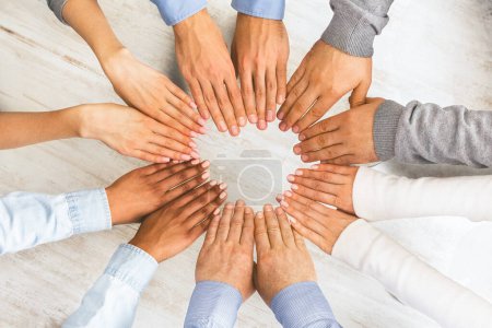 Photo for Teambuilding And Cooperation Concept. Multiethnic Group Of People Making Circle Of Their Hands As a Sign Of Unity, Top View - Royalty Free Image