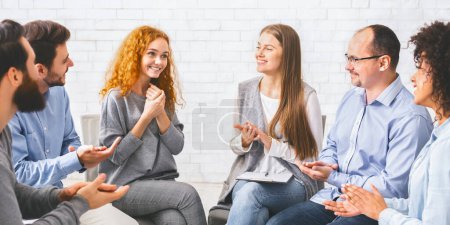 Photo for New group member. People applauding to young woman at therapy session in rehab, greeting her in community. - Royalty Free Image