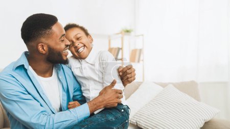 Afro-Vater kitzelt Tochter, hat Spaß und spielt zu Hause zusammen