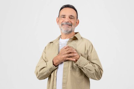 Photo for Gratitude Concept. Thankful Elderly Man Keeping Both Palms On Chest, Smiling Senior Gentleman Expressing Appreciation And Kindness While Standing Isolated Over Yellow Background, Copy Space - Royalty Free Image