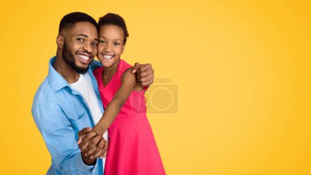 Téléchargez les photos : Homme afro-américain dansant avec sa fille sur fond jaune - en image libre de droit