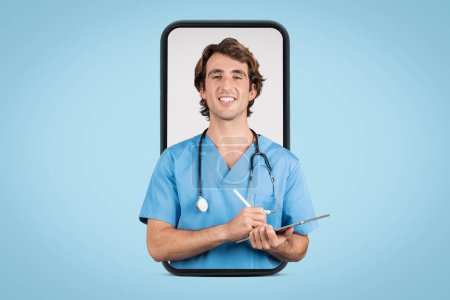 Téléchargez les photos : Joyeux jeune infirmier en bleuets bleus tenant la tablette, avec stéthoscope autour du cou sur fond bleu, représentant la technologie des soins de santé et l'engagement du patient - en image libre de droit