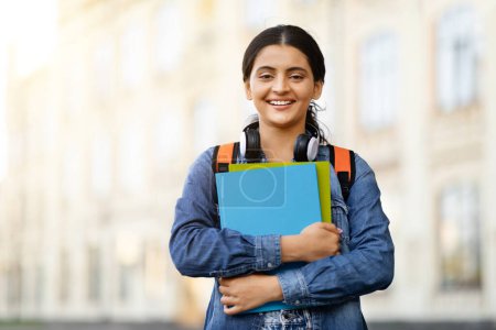 Photo for Beautiful Young Indian Woman Student Standing Outdoors With Workbooks In Hands, Happy Attractive Eastern Lady Posing Outside On City Street, Carrying Backpack And Smiling At Camera, Copy Space - Royalty Free Image