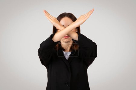 Téléchargez les photos : Femme d'affaires caucasienne millénaire avec les yeux couverts de mains croisées faisant un signe X, symbolisant le rejet, le déni ou l'évitement, placé sur un fond clair, studio - en image libre de droit