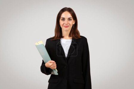Photo for Professional caucasian millennial businesswoman holding folders, ready for meeting or to manage tasks, embodying organization and preparedness in workplace, isolated on gray background, studio - Royalty Free Image