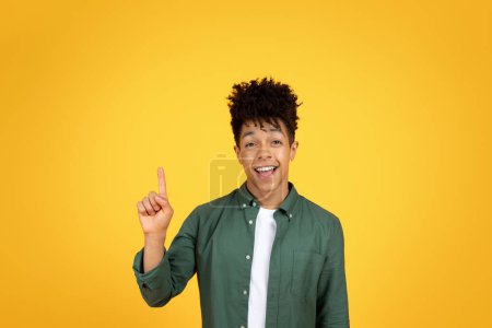 Photo for Inspired millennial african american guy raising finger up and exclaiming, have great creative idea, isolated on yellow studio background, copy space - Royalty Free Image