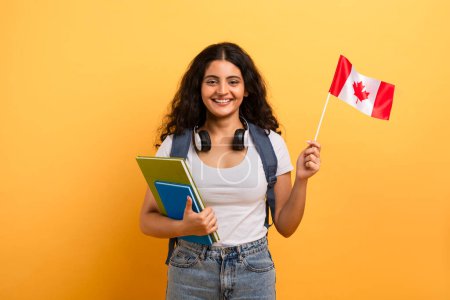 Téléchargez les photos : Joyeux jeune apprenant arborant un drapeau canadien, représentant la fierté et l'identité culturelle - en image libre de droit