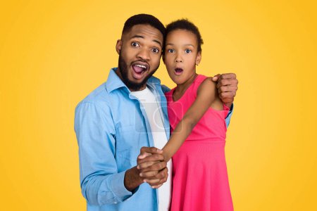 Photo for Emotional father and daughter having fun on yellow background - Royalty Free Image