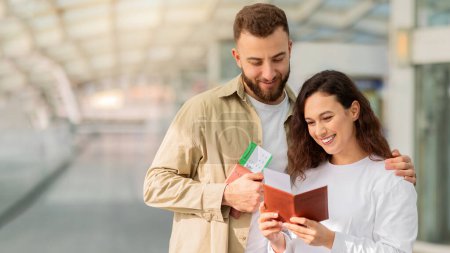 Photo for Young Happy Couple Waiting For Flight Boarding At Airport Terminal, Cheerful Man And Woman Checking Passports And Tickets, Ready For Vacation Trip, Enjoying Travelling Together, Copy Space - Royalty Free Image