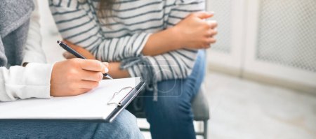Photo for Psychological help. Specialist taking notes during psychotherapy session with young woman, crop - Royalty Free Image