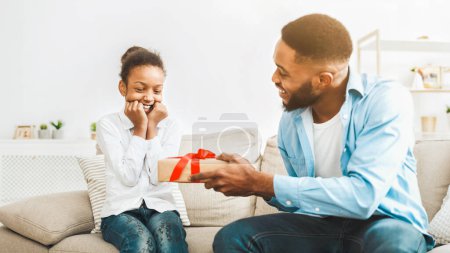 Holiday Gift. African Father Giving Birthday Present For Daughter, Making Surprise At Home