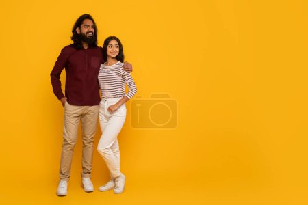 Photo for A man and woman stand back-to-back with arms crossed, emanating a relaxed vibe against a yellow background - Royalty Free Image