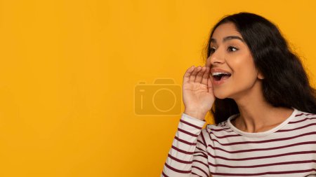 Photo for A woman with mouth open shouting or calling out, with a yellow background emphasizing her action - Royalty Free Image
