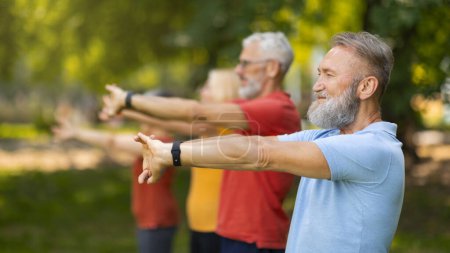 Photo for Focused seniors performing yoga pose in unison during outdoor training in park, elderly people demonstrating health and balance, enjoying active lifestyle on retirement, side view, selective focus - Royalty Free Image