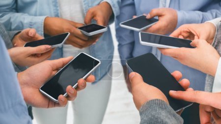 Photo for Modern communication and gadget addiction concept. Closeup of diverse people standing in circle holding smartphones, panorama - Royalty Free Image