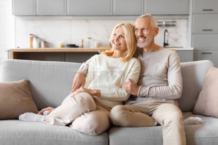 Photo for Affectionate senior couple sitting comfortably on a couch, conveying a sense of contentment and companionship - Royalty Free Image
