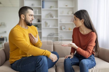 Photo for A man and woman are sitting on a couch, engaged in a deep and serious conversation, possibly discussing issues - Royalty Free Image