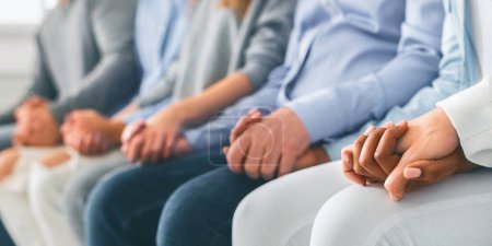 Photo for Group therapy. Unrecognizable people sitting in a row and holding hands during session in rehab, panorama, cropped image - Royalty Free Image