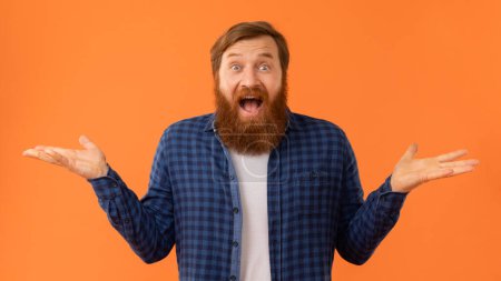 Excited Redhaired Bearded Man Holding Hands With Open Palms Up, Comparing Two Invisible Objects Or Shrugging Shoulders With Emotional Expression, Standing Over Orange Background, Panorama